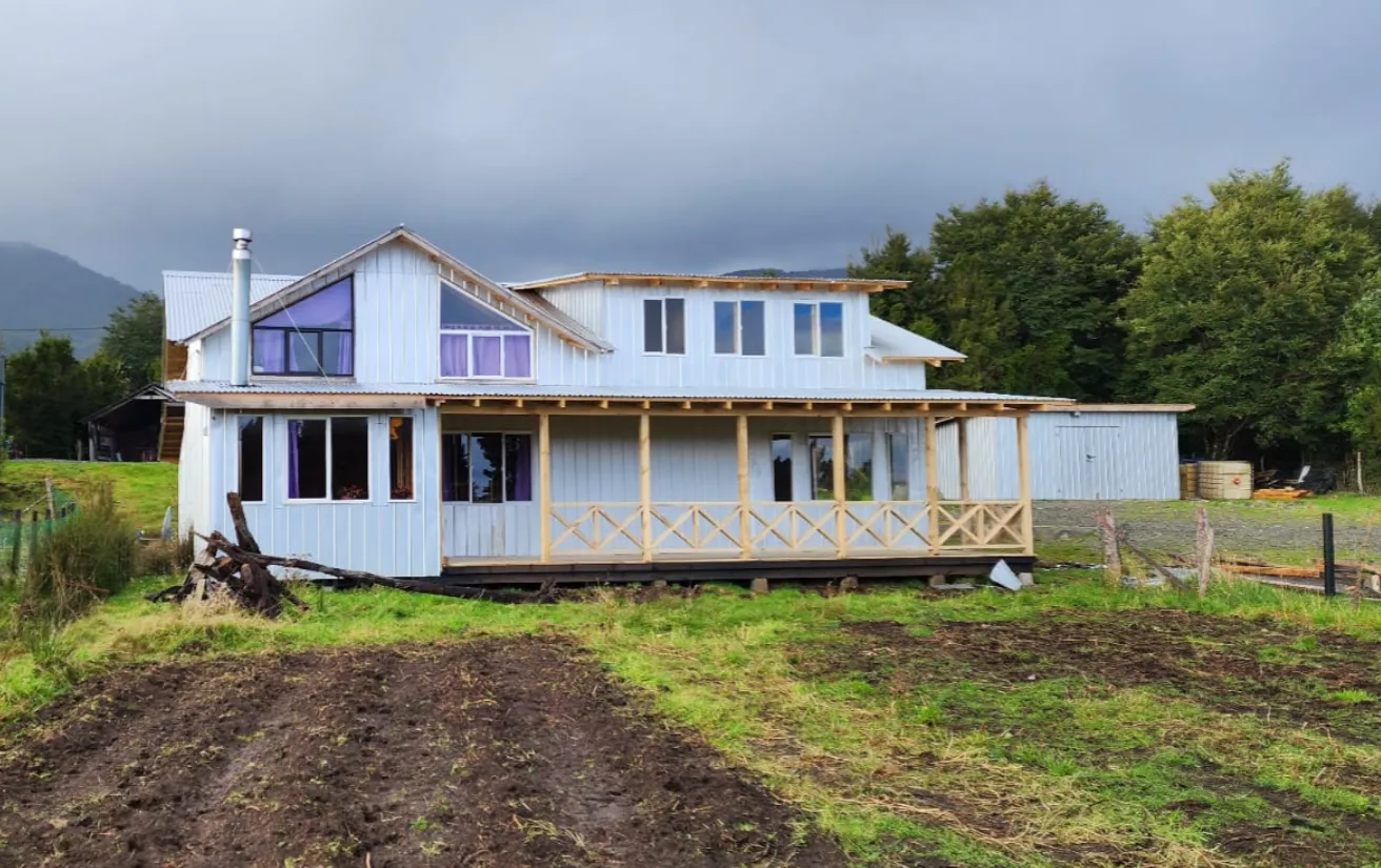 Cabaña de madera privada con una terraza y una hamaca, rodeada de bosque nativo.