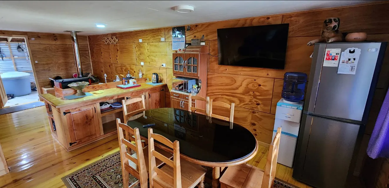 Vista exterior de una cabaña de madera entre los árboles.